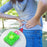 Small green hot water bag with cover for body warmth and pain relief
