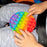 Round pop it stress toy with colorful bubbles.